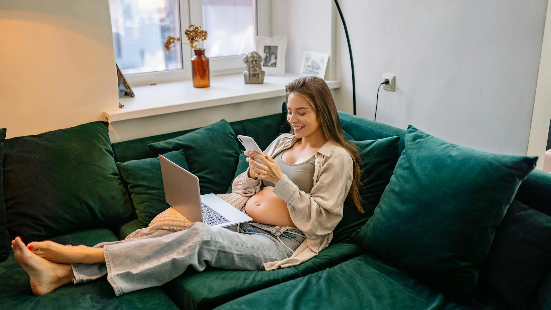 Femme enceinte allongée confortablement sur son canapé à la maison, moment de pause